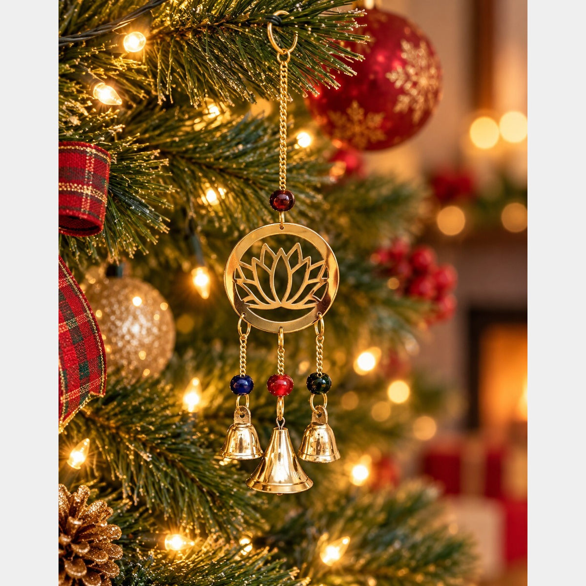 Brass lotus chime suspended by a chain on a Christmas tree, with colorful beads and three hanging bells