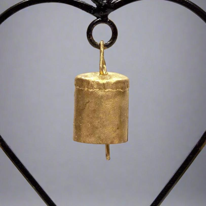 Iron heart shaped chime with four small tin bells hanging from a black iron frame, 7.25 inches tall, closeup, TS102.