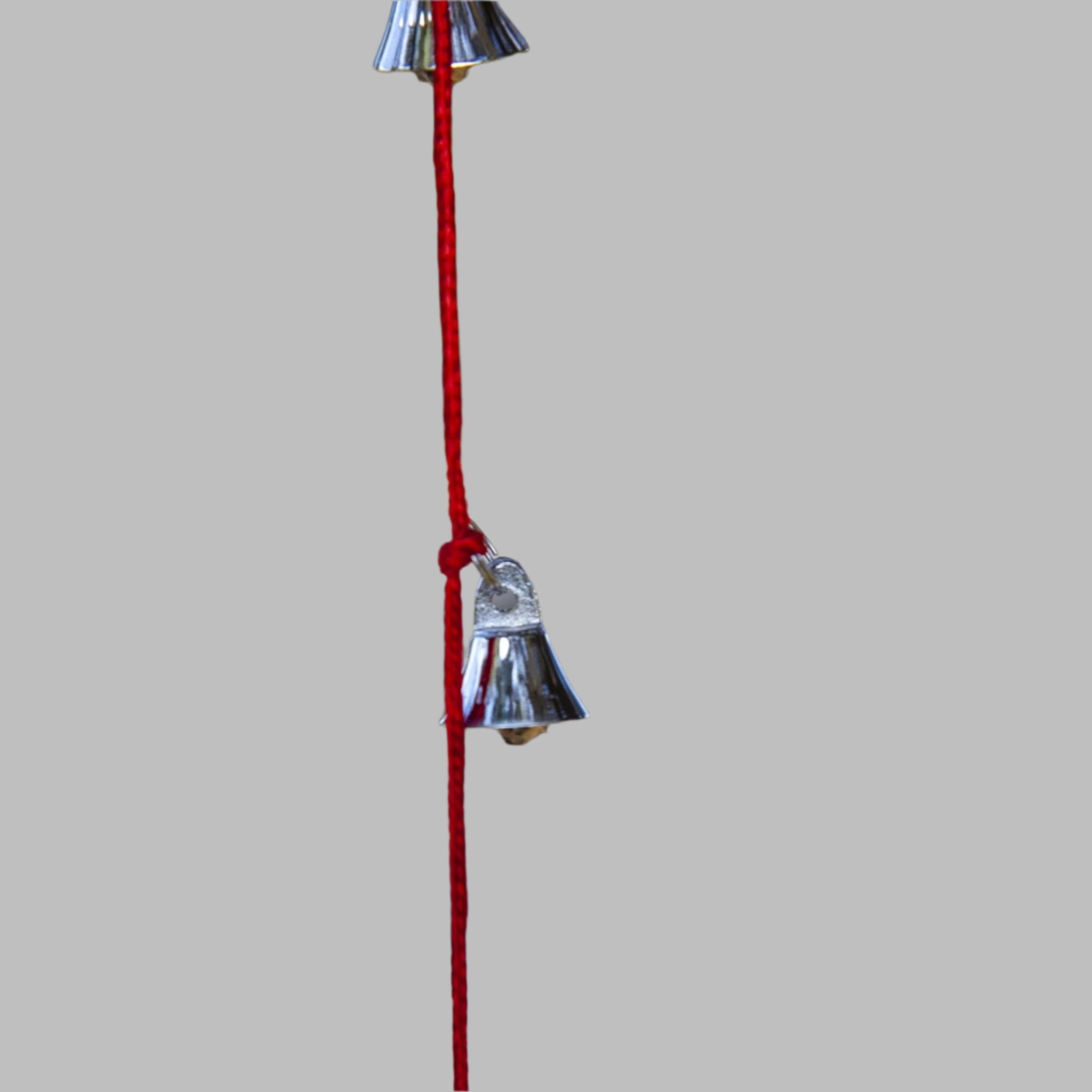 Strand of small silver tone brass bells hanging on green purple black and red cords, each cord about 30 inches long, BS011.