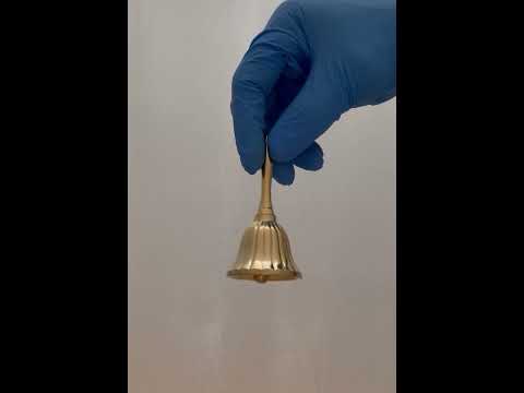 Video of a 3.5-inch tall brass hand bell being rung, showcasing its clear and resonant sound. The bell has a polished finish and a classic design, ideal for decorative or functional use.